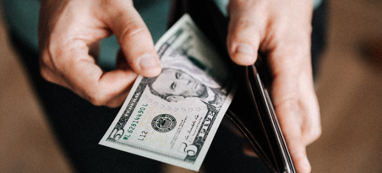 a man putting a 5 dollar bill in his wallet 