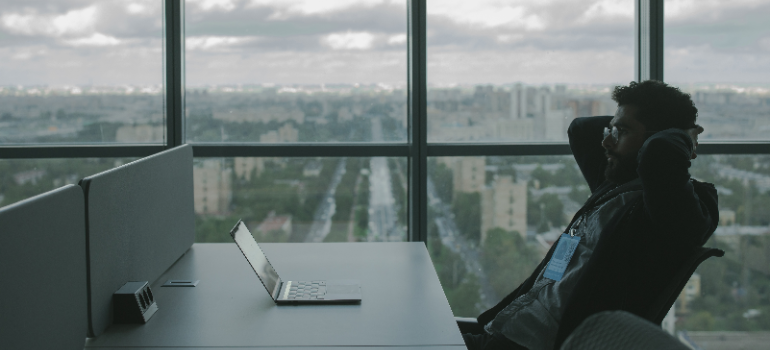 A man looking at his laptop and organizing files. 