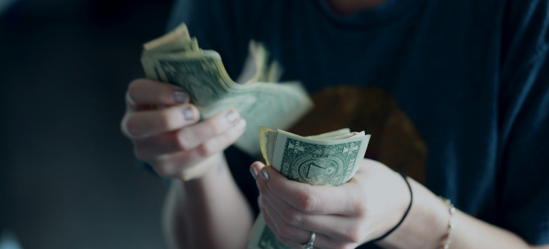 a person counting money because of moving to Brandon