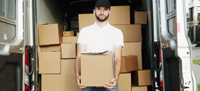 man smiling while holding a box