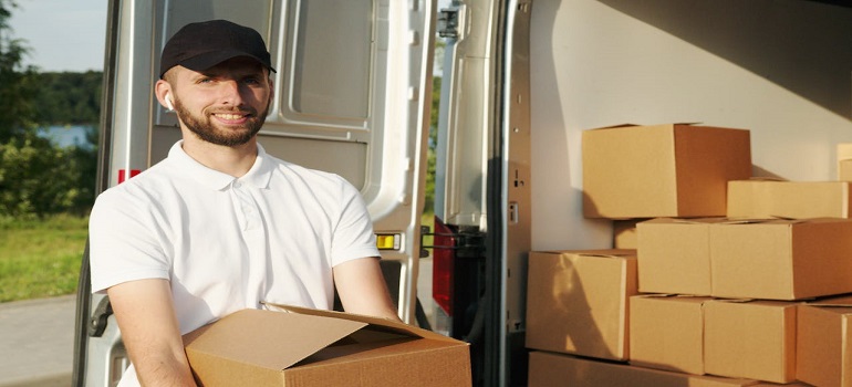 a man in white shirt and black hat holding a box