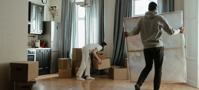 Two people carrying their belongings