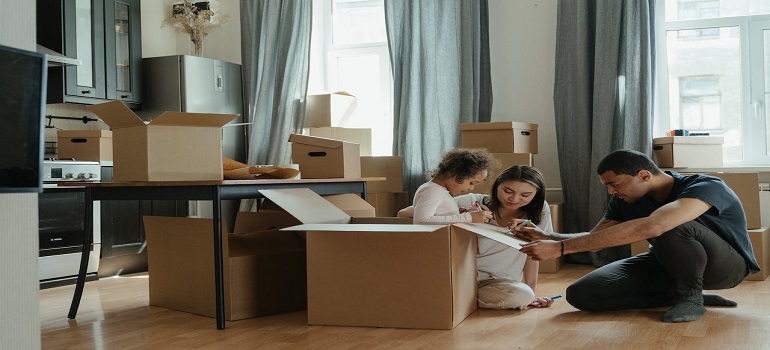 family surrounded with lots of boxes after dealing with moving day challenges in Coastal Florida