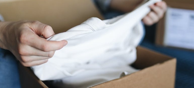 A person unpacking clothes out of a box