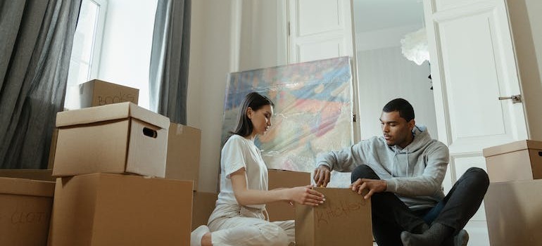 A couple following the tips to expedite unpacking by unpacking one room at a time