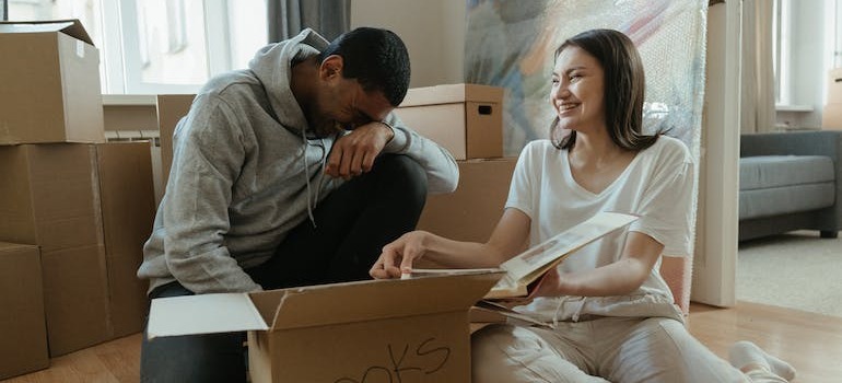 A couple taking a break from unpacking by looking at an old album