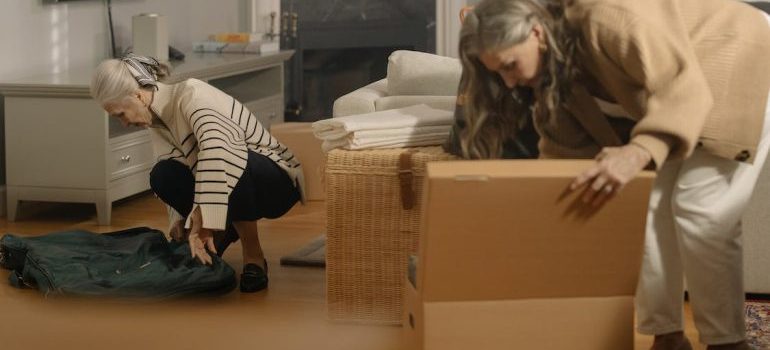 Two elderly women packing during the move