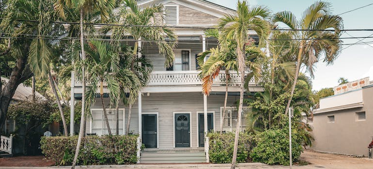 a white house with palm trees in front in one of the most romantic Florida cities