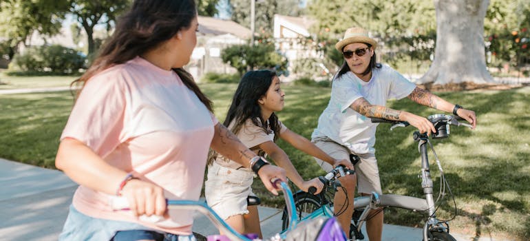 Two women and a little girl riding bikes while talking about family-friendly activities in Tallahassee