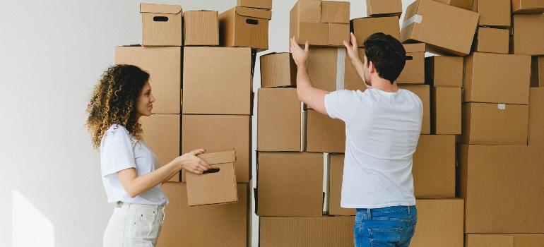 two people next to numerous boxes