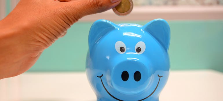 Person putting a coin in the piggy bank