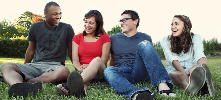 four young people sitting on the grass