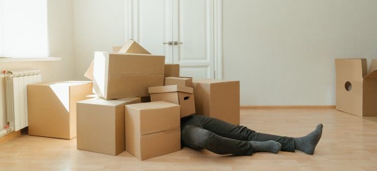 A person lying among boxes and waiting for a junk removal Connecticut company