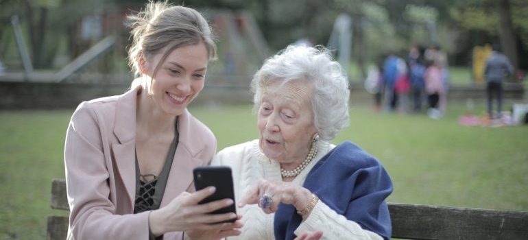 A young woman showing something to an old woman